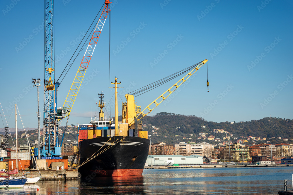 Container ship and cranes for unloading and loading in the seaport, Gulf of La Spezia, Liguria, Italy, Europe