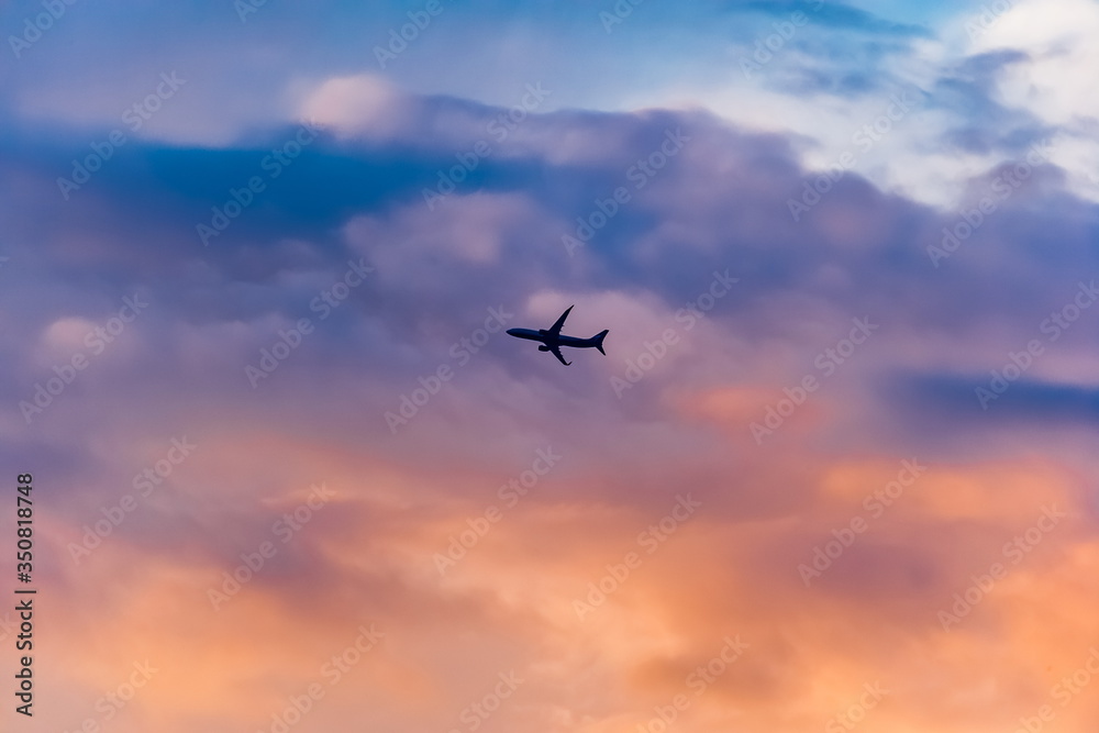 Airplane against the sky with clouds at sunset in summer (background, banner, Wallpaper, texture)