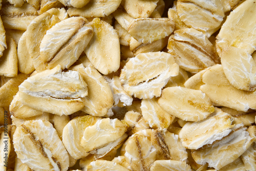 Close up of oats flakes. oats flakes macro shoot. Oatmeal flakes texture. Background of golden oat flakes. Healthy food.