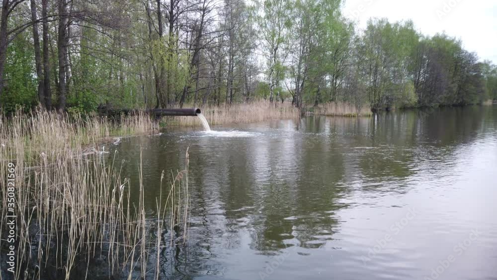 Waste emissions into water, water pollution. A large pipe from the plant pollutes the ecology of the river. Waste emissions into water, water pollution. A large pipe from the plant pollutes the ecology of the river.