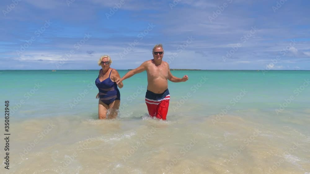 Active Senior Couple Walking in water on Hawaii island in 4K slow motion 60fps Active Senior Couple Walking in water on Hawaii island in 4K slow motion 60fps