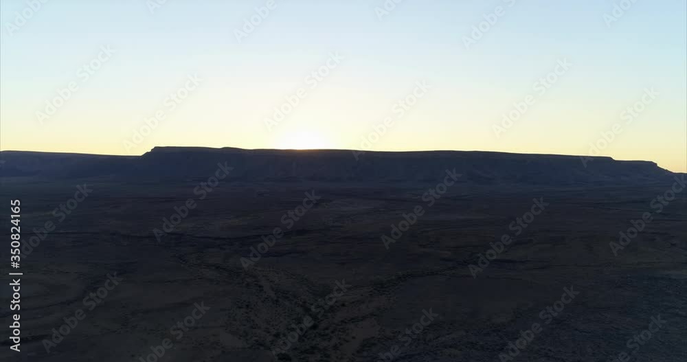Aerial shot of mountain in desert against sky during sunset, drone ascending over arid landscape - Namib Desert, Namibia Aerial shot of mountain in desert against sky during sunset, drone ascending over arid landscape - Namib Desert, Namibia