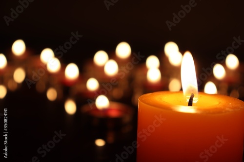 Close-Up Of Candles Burning On Table Against Black Background