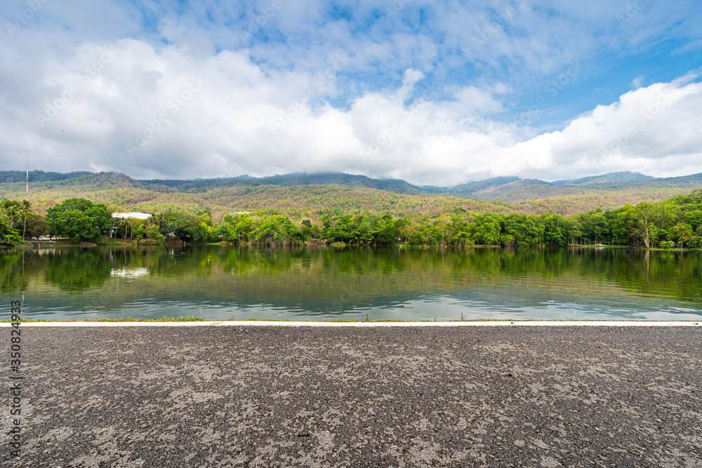 Asphalt black grey road landscape lake views at Ang Kaew Chiang Mai University in nature forest Mountain views spring blue sky background with white cloud.