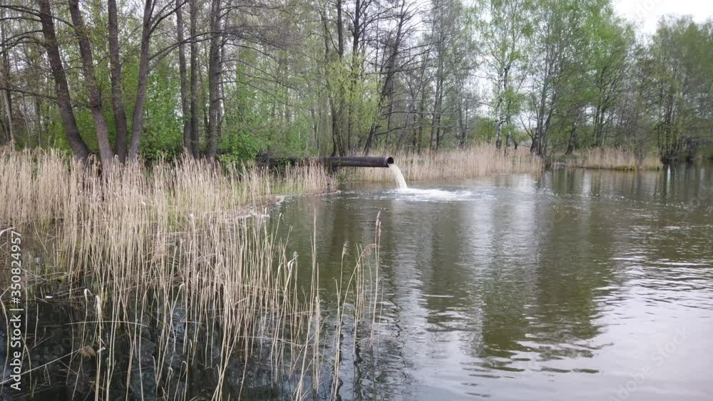 Waste emissions into water, water pollution. A large pipe from the plant pollutes the ecology of the river. Waste emissions into water, water pollution. A large pipe from the plant pollutes the ecology of the river.