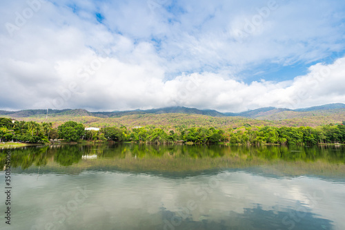 landscape lake views at Ang Kaew Chiang Mai University in nature forest Mountain views spring blue sky background with white cloud.