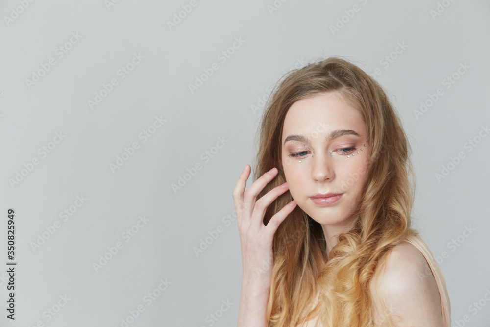 A girl with long blond hair on a gray background. A girl with long blond hair on a gray background.