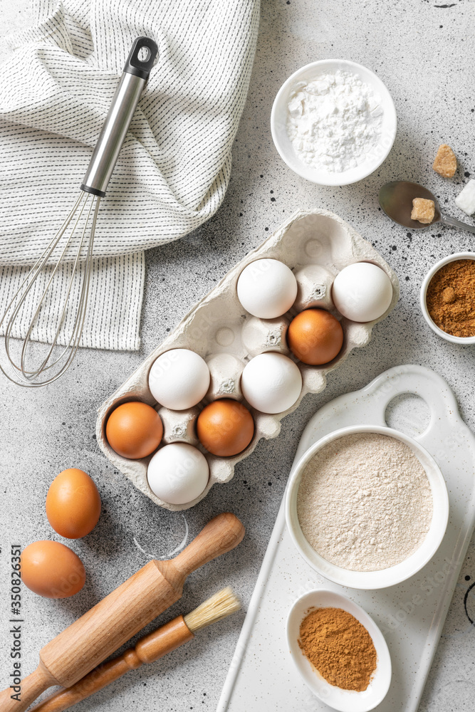 Ingredients for baking on a culinary background. Eggs, flour, cinnamon, sugar, soda on the kitchen table. Concept of preparation for baking. Top view with space for text