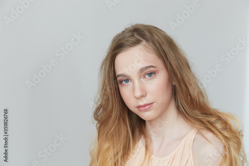 A young beautiful girl with blue eyes and long blond hair.