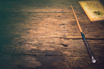 Magic wand on old wooden table.