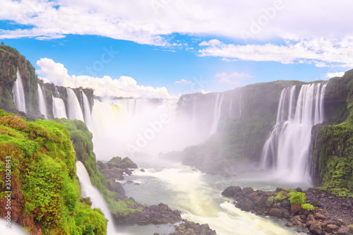 Iguazu waterfalls in Argentina, view from Devil's Mouth. Panoramic view of many majestic powerful water cascades with mist. Long exposure, long water. Panorama of Iguazu valley from top point. © tilialucida