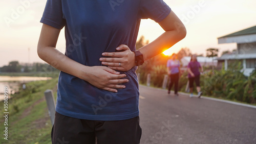 stomach ache concept. Sport injury, stomach ache after running and exercise outside in summer.