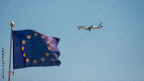 european union flag, flying airplane in the sky against the background of the flag of the European Union, flying under quarantine conditions, pandemics around the world, air carriers in quarantine