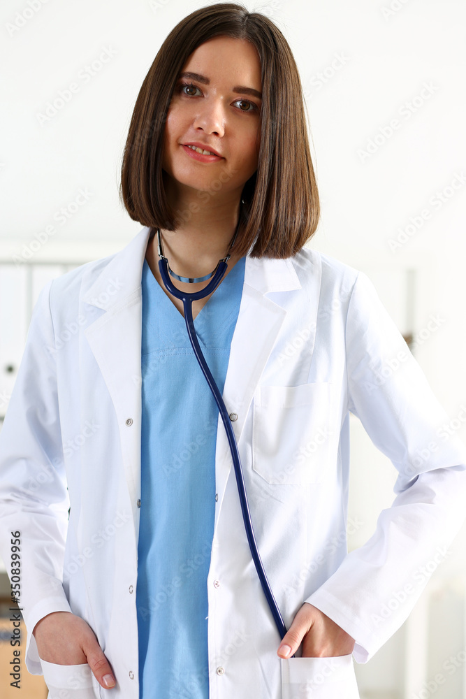 Beautiful smiling female doctor stand in office portrait Beautiful smiling female doctor stand in office portrait