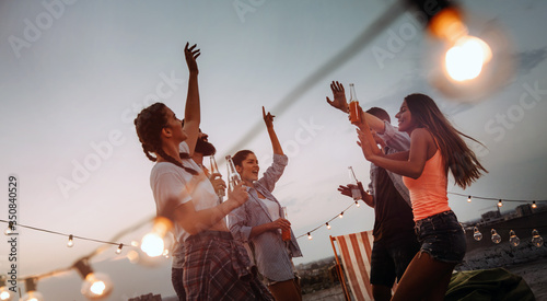 Photography Carefree group of happy friends enjoying party on rooftop terrace