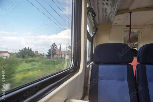 Empty seats in a modern regional train, European style, on a travel in a countryside with a speed blur effect seen from the window © Jerome