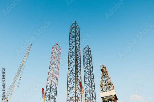 Jack Up Oil Rig (Drilling Rig) and Rig Crane on blue sky background.