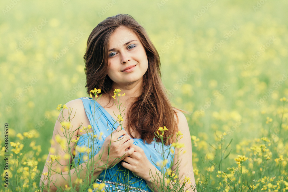 beautiful romantic girl on blooming rapeseed field enjoying nature, young elegant woman walks beautiful romantic girl on blooming rapeseed field enjoying nature, young elegant woman walks