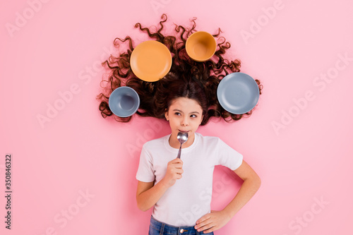 Top view above high angle flat lay flatlay lie concept portrait of her she nice attractive beautiful wavy-haired girl licking spoon dishes meal isolated over pink pastel color background photo