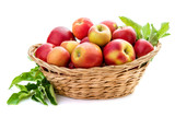 Red-yellow apples with leaves in a wicker basket. Isolate on white background