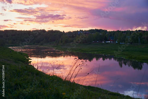 The bright sunset sky is reflected in the river.