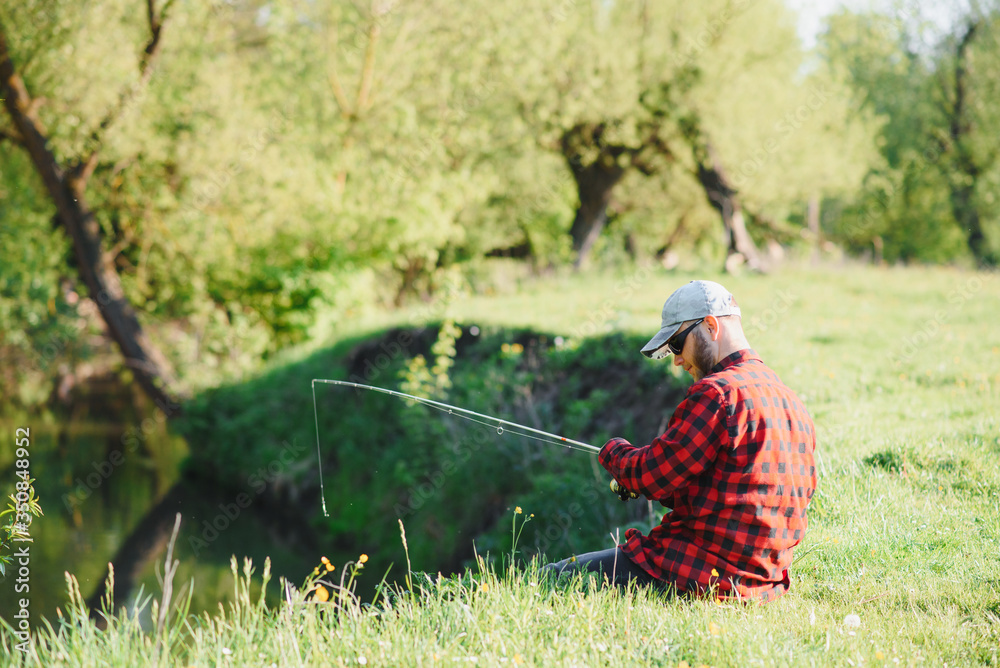 Man relaxing and fishing by lakeside. Weekends made for fishing. Fisher masculine hobby. Master baiter. Keep calm and fish on. Fishman crocheted spin into the river waiting big fish. Guy fly fishing Man relaxing and fishing by lakeside. Weekends made for fishing. Fisher masculine hobby. Master baiter. Keep calm and fish on. Fishman crocheted spin into the river waiting big fish. Guy fly fishing