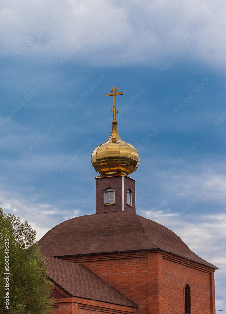 The dome of the Orthodox Church with a cross on blue sky background