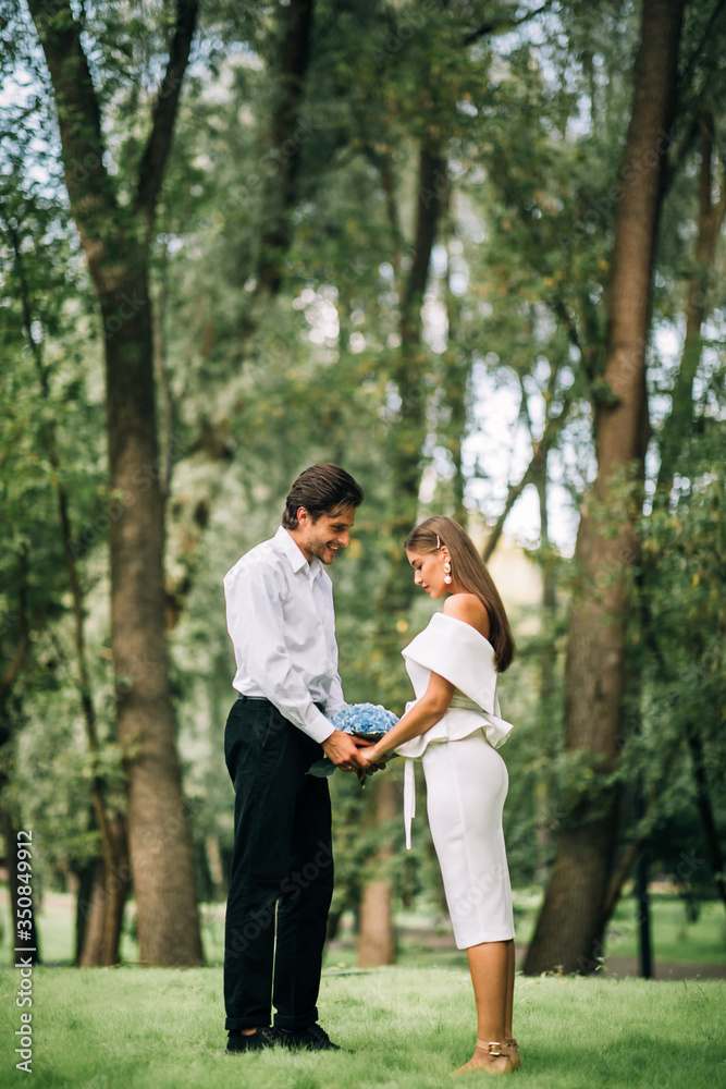 Fototapeta premium Bride And Groom In Love Holding Hands Standing In Park