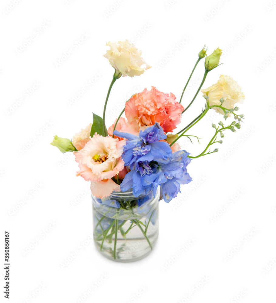 several flowers (blue, orange-yellow) in a glass jar with water