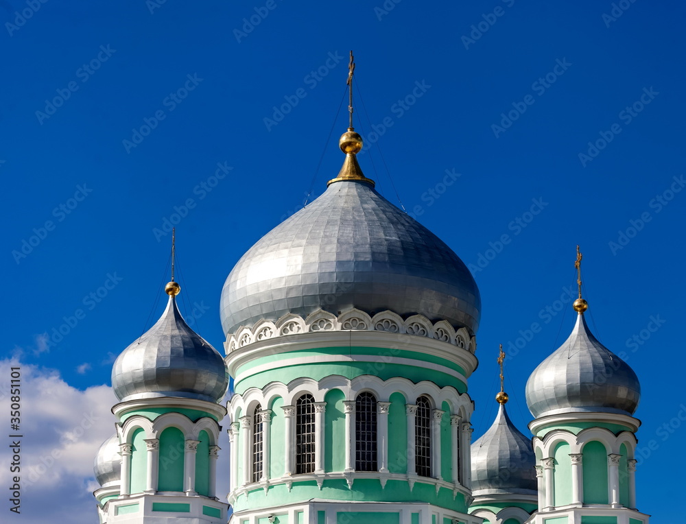 Dome of the Orthodox Church against the blue sky with clouds in summer closeup