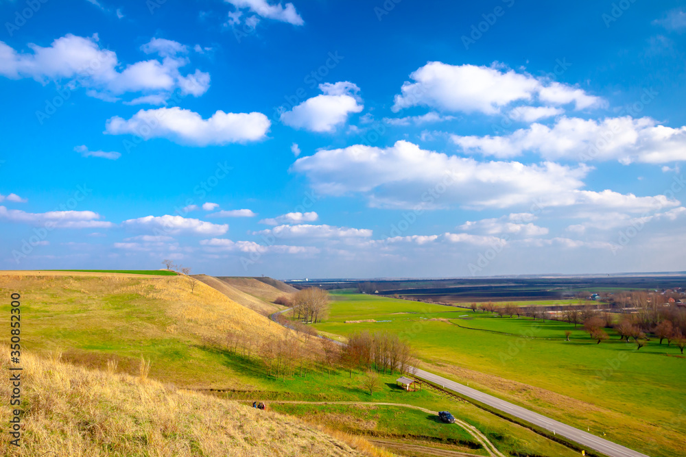 Green hilly landscape and blue cloudy sky