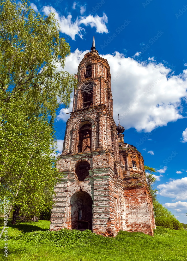 Abandoned Orthodox Church in summer against the blue sky and white clouds