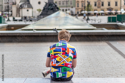 Man in a colorful polo sitting on the bench