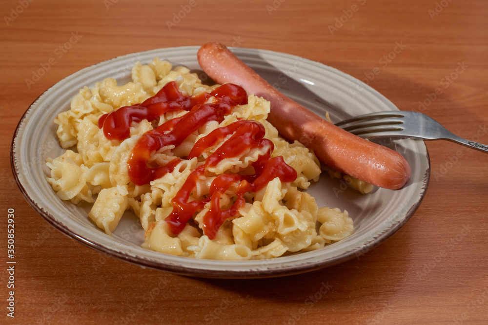 Italian pasta with sausages in tomato sauce with a rustic table background Italian pasta with sausages in tomato sauce with a rustic table background