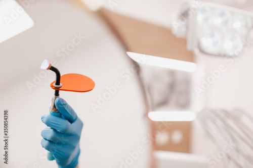 Dental instrument in hand with blue gloves on a white background. Dental clinic hygiene photo