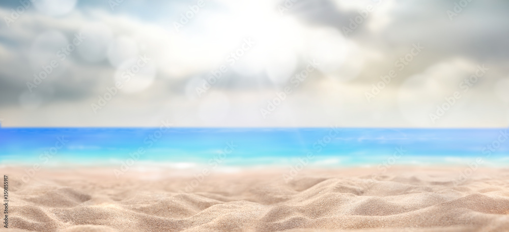 A summer vacation, holiday background of a tropical beach and blue sea and sun breaking through clouds.