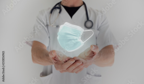Male doctor hands holding face mask to protect us against Covid-19