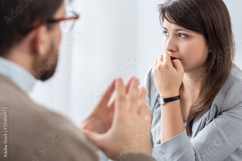 Worried beautiful young woman with social problems during psychotherapy photo