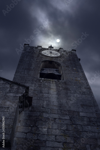 Billede på lærred Old bell tower in a cloudy full moon night