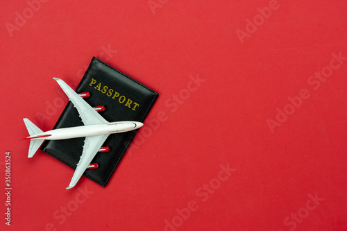 Table top view accessory of accessory travel in holiday background concept.Flat lay of airplane with passport card on modern rustic red paper at home studio office desk.copy space for design.