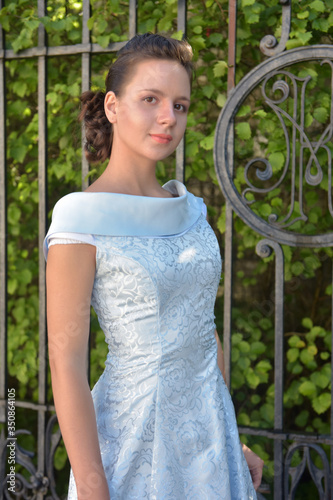 Beautiful brunette in pale blue evening dress outdoor. photo