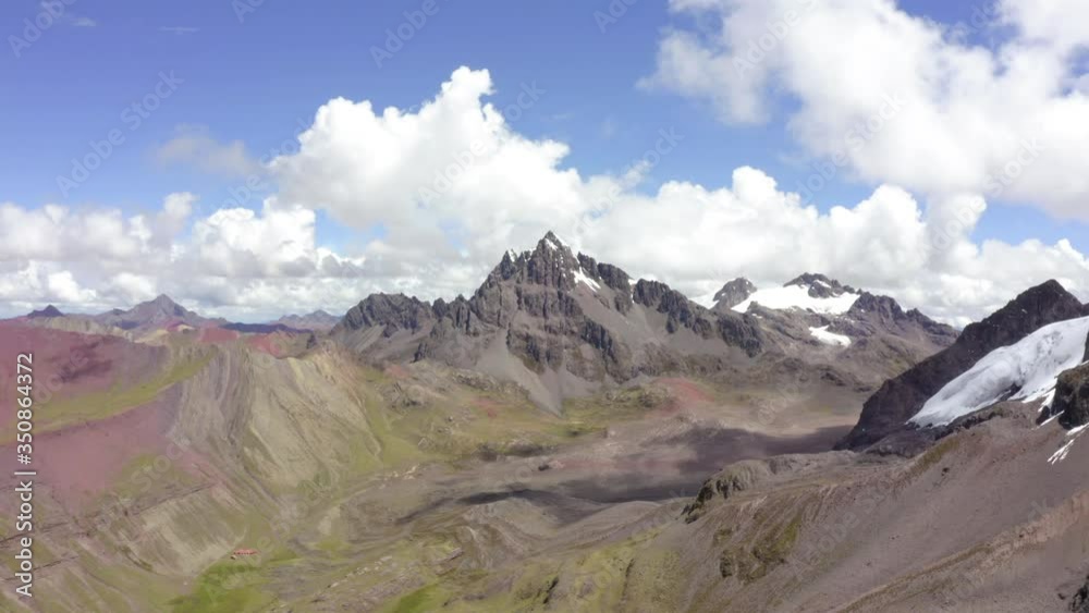 Aerial shot of beautiful rocky mountains against sky on sunny day, drone ascending over barren landscape in desert - Rainbow Mountain, Peru Aerial shot of beautiful rocky mountains against sky on sunny day, drone ascending over barren landscape in desert - Rainbow Mountain, Peru