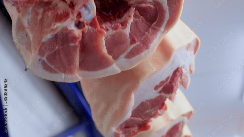 Food industry, meat processing. Pig carcasses close up on hooks against the background of a meat processing plant