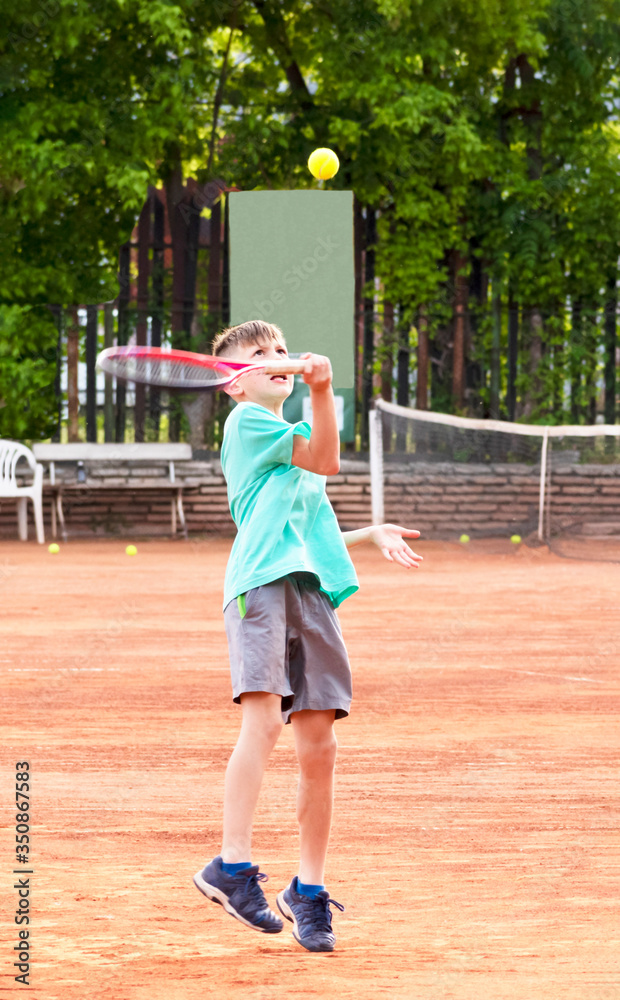 A boy on the tennis court. The face of a young tennis player during a game. Kids tennis. Professional children's tennis sports. Sports anger, the will to win. Selective Focus.