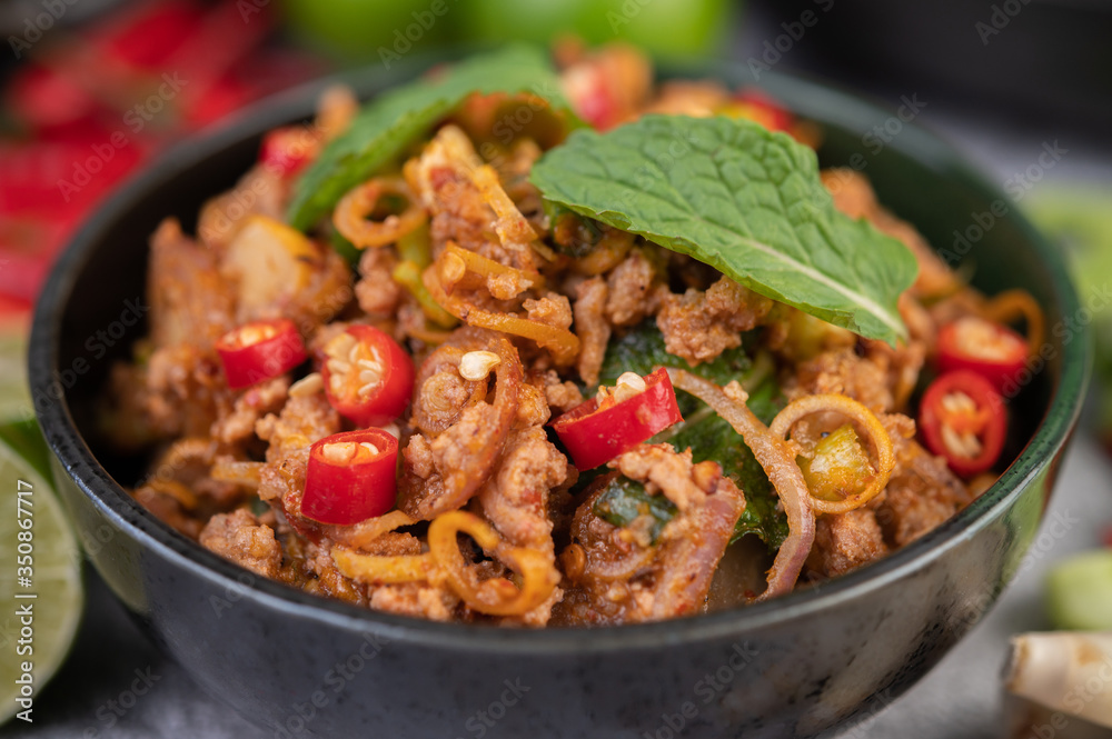 Spicy pork chops in a black cup consisting of lemons Chili and side dishes Spicy pork chops in a black cup consisting of lemons Chili and side dishes