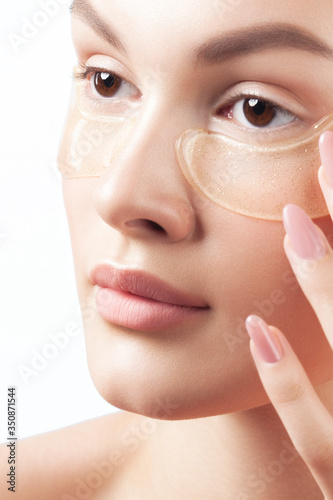 Young beautiful woman with clean perfect skin with cosmetic patches on face close-up