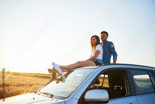 Smiling  couple sitting and enjoying the view. © gpointstudio