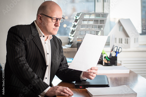 A man in a suit reads a doc...
