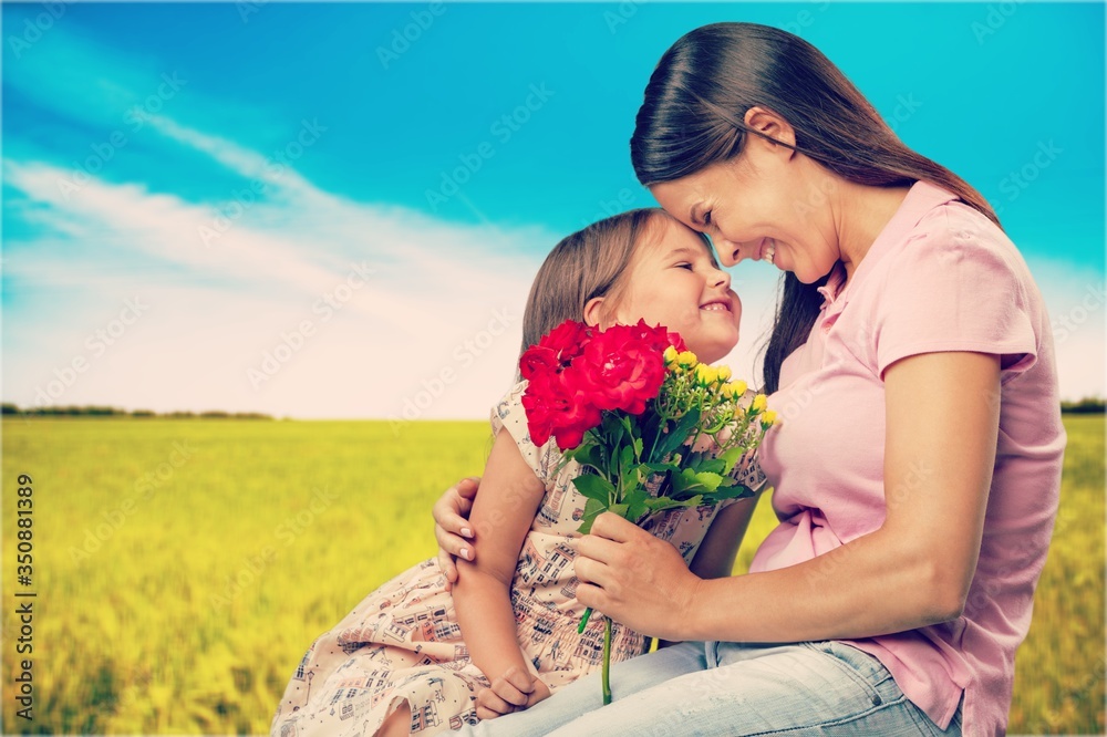 Mother and daughter with a bouquet of flowers on nature background. Mother and daughter with a bouquet of flowers on nature background.