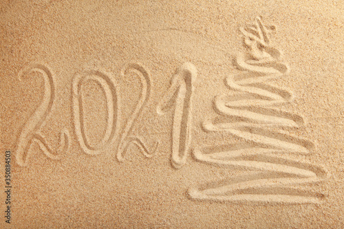 2021 new year text with christmas tree on sand background